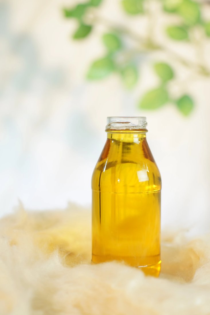 Kapok seed oil — golden bottle on kapok fibre