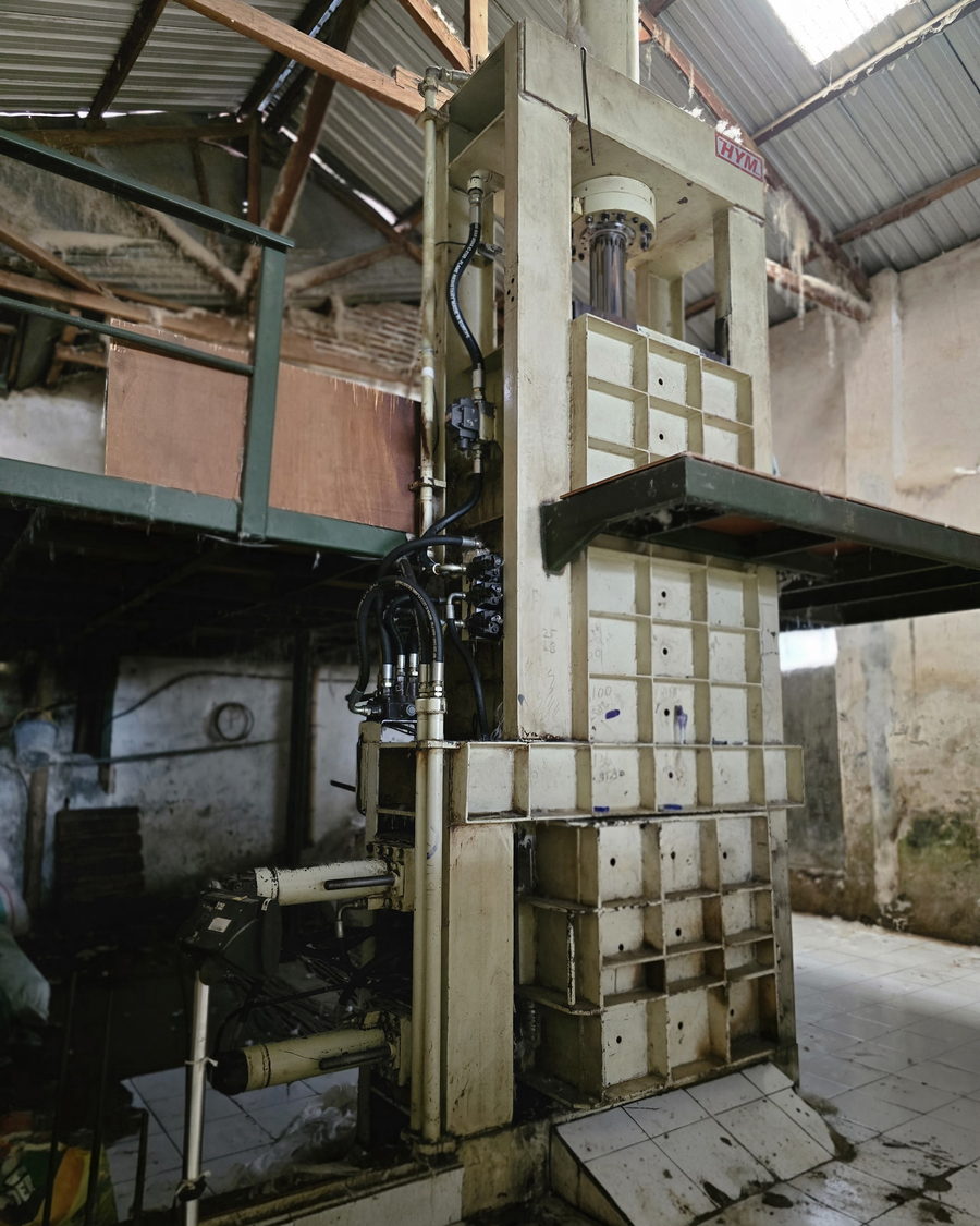 Hydraulic press compressing kapok into export bales
